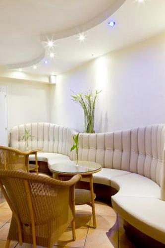 a room with a couch and a table and chairs at Buchholz Downtown Hotel in Cologne