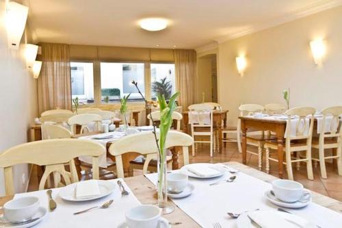 a dining room with white tables and chairs at Buchholz Downtown Hotel in Cologne