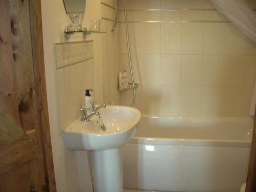 a bathroom with a sink and a toilet and a tub at The Boathouse in Callington