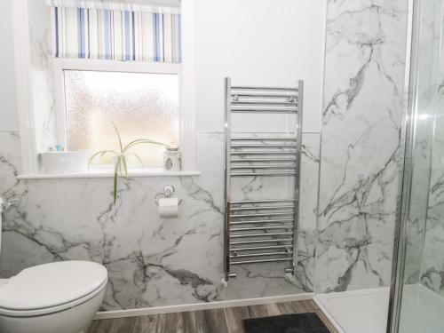 ein Badezimmer mit Toilette und Glasdusche in der Unterkunft Gabby's Garden Cottage in Hull