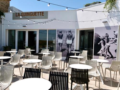 a group of tables and chairs in front of a building at Hôtel Atalante - Relais Thalasso & Spa in Sainte-Marie-de-Ré