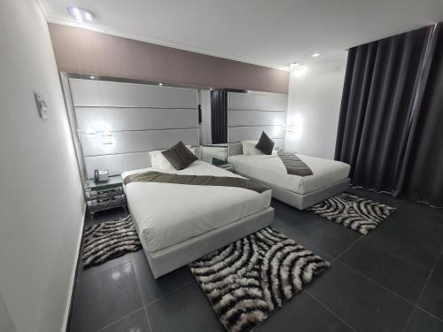 um quarto de hotel com duas camas e um sofá em Indico Executivo Hotel na Cidade de Nacala