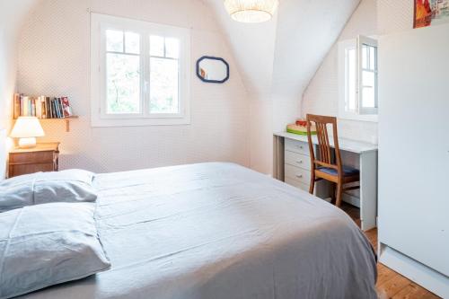 ein Schlafzimmer mit einem Bett, einem Schreibtisch und einem Stuhl in der Unterkunft Ti Maen in Frehel