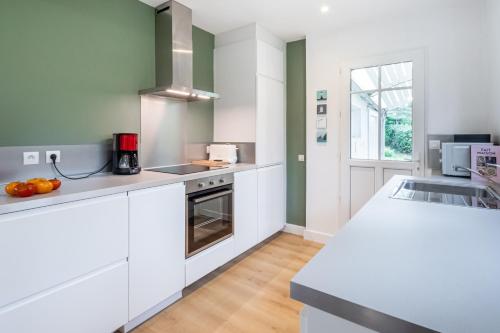 une cuisine avec des armoires blanches et un évier dans l'établissement Ti Maen, à Fréhel