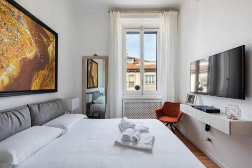 een witte kamer met een bed en een televisie bij Easylife - Luxury apartament in Cadorna Duomo MXP in Milaan