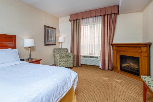 a hotel room with a bed and a fireplace at Holiday Inn Express Hotel & Suites Clarington - Bowmanville, an IHG Hotel in Bowmanville