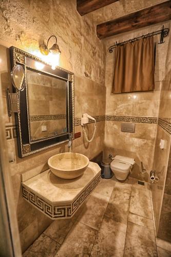 a bathroom with a sink and a toilet at Göreme Cave Suites in Goreme