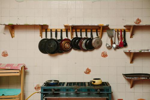 a kitchen with pots and pans hanging on a wall at Nopalero Hostel in Puerto Escondido