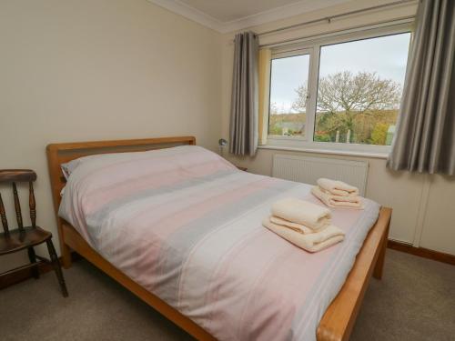 1 dormitorio con 1 cama con toallas en Avalon, en Cardigan