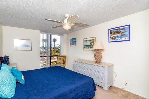 a bedroom with a blue bed and a ceiling fan at Condo in Beachfront Resort B-212 in Oceanside