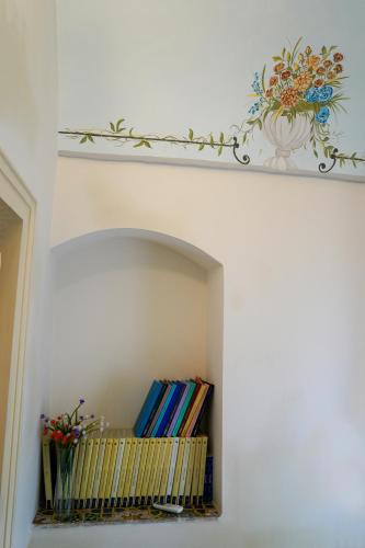 a shelf with books and a painting on a wall at Modica Castle in Modica