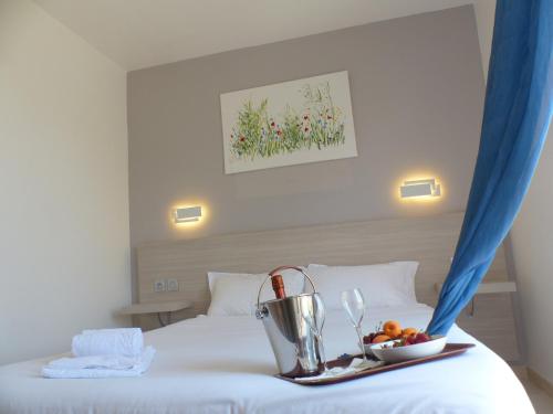 una camera d'albergo con un vassoio di frutta su un letto di Stella Marina a Macinaggio