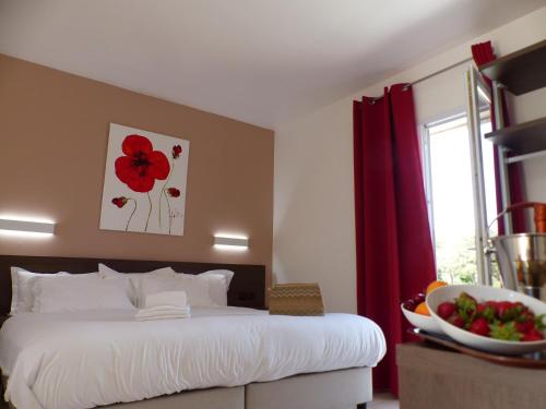 - une chambre avec un lit orné d'un tableau de fleurs rouges sur le mur dans l'établissement Stella Marina, à Macinaggio