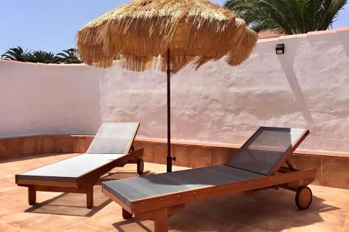 two chairs and an umbrella on a patio at Rio Sol - Oasis de Privacidad in Costa Calma