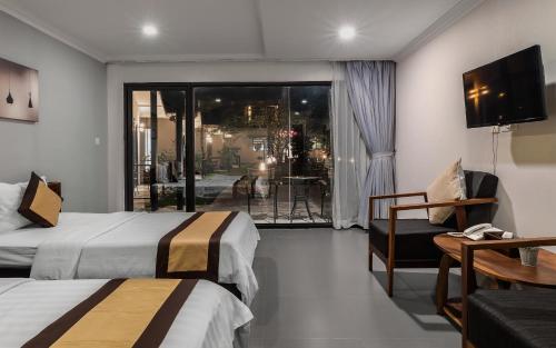 a hotel room with two beds and a balcony at Sandy Clay Bungalows in Sihanoukville