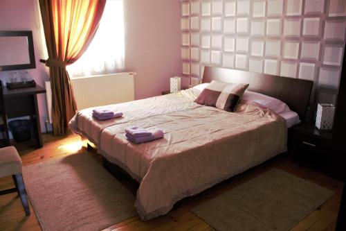 a bedroom with a large bed with two towels on it at Garni Hotel City in Kruševac