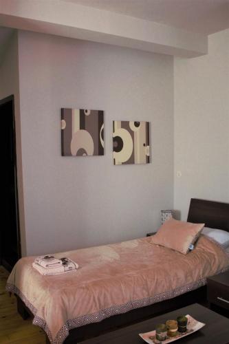 a room with a bed with three pictures on the wall at Garni Hotel City in Kruševac