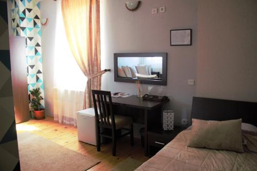 a bedroom with a desk and a bed and a desk with a chair at Garni Hotel City in Kruševac