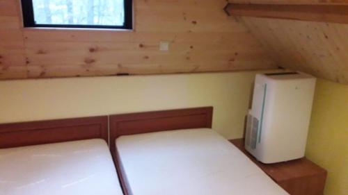 トゥラバにあるDomek Annaのベッド1台、小型冷蔵庫が備わる小さな客室です。