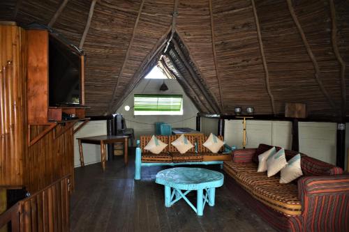 una sala de estar con un sofá y una mesa en Tortugal Boutique River Lodge, en Río Dulce