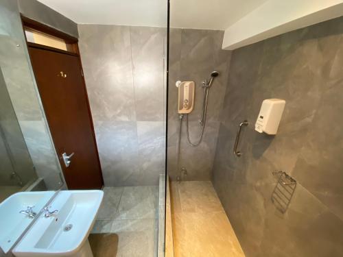 uma casa de banho com um chuveiro e um lavatório. em Progressive Park Hotel em Nairobi