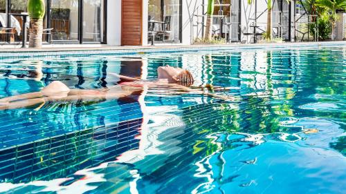 a woman swimming in a swimming pool at Sandy Clay Bungalows in Sihanoukville