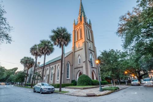 a church with a tower with a car parked in front at Garden Level on Charlton in Savannah