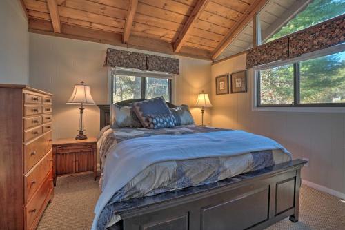 een slaapkamer met een bed, een dressoir en 2 ramen bij Serene Sky Valley Home with 180 Degree Mountain View in Sky Valley