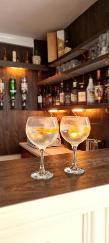 Dois copos de vinho em cima de um bar. em Sunnycroft Private Hotel em Llandudno
