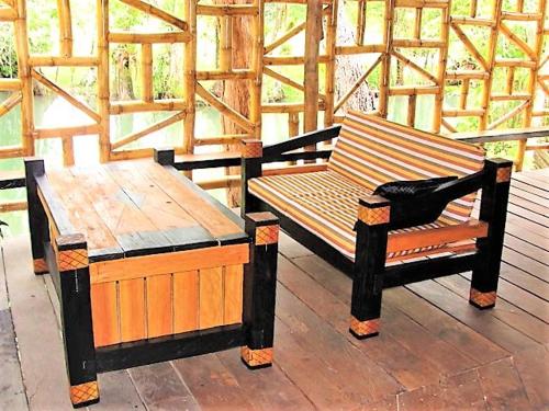 two benches sitting on top of a wooden deck at Tortugal Boutique River Lodge in Rio Dulce