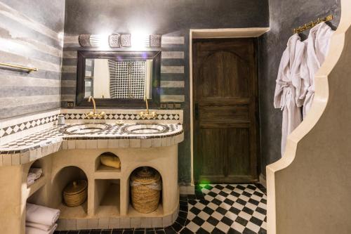 a bathroom with a large sink and a mirror at Riad Madu in Merzouga