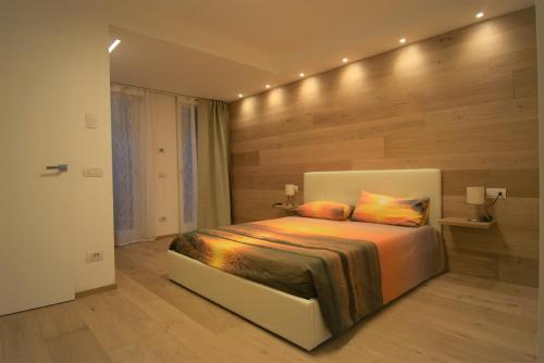 1 dormitorio con 1 cama grande y pared de madera en Appartamento Margherita - Bellagio Wild Flowers en Oliveto Lario