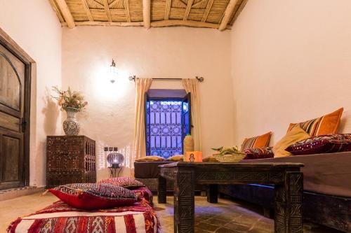 a living room with a couch and a table at Riad Madu in Merzouga