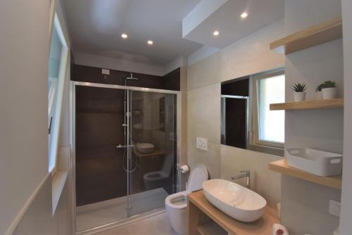y baño con ducha, aseo y lavamanos. en Appartamento Margherita - Bellagio Wild Flowers en Oliveto Lario