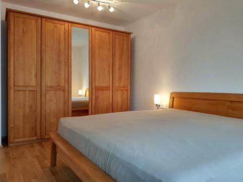 um quarto com uma cama grande e armários de madeira em Apartment "SUN" em Friedrichshafen