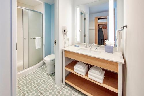 a bathroom with a sink and a toilet and a mirror at Universal’s Endless Summer Resort – Dockside Inn and Suites in Orlando
