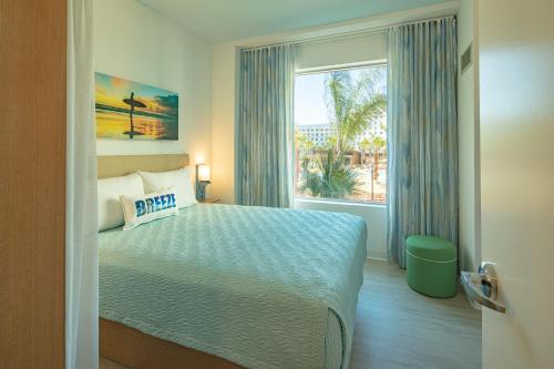 a bedroom with a bed and a large window at Universal’s Endless Summer Resort – Dockside Inn and Suites in Orlando