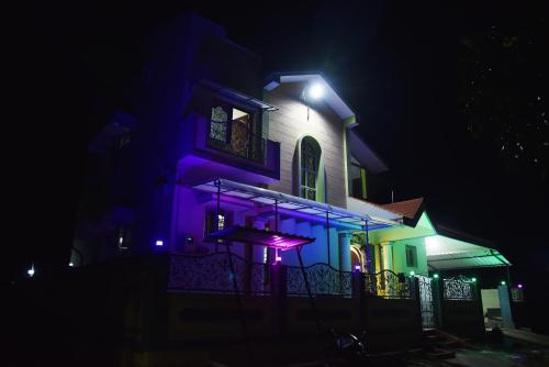 a house lit up in purple and green at night at jayaram Home in Chittoor