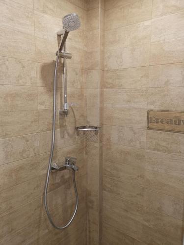 a shower with a shower head in a bathroom at Загора апартмент in Stara Zagora