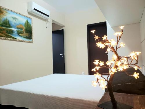 ein Schlafzimmer mit einem Bett und einem Baum mit Lichtern in der Unterkunft Lindo Apto na Praia dos Ingleses in Florianópolis