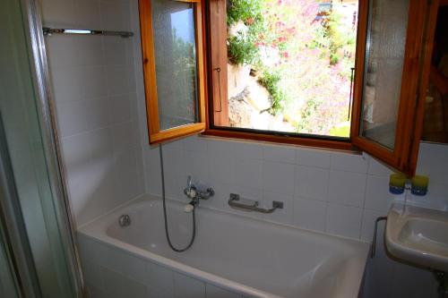 baño con bañera, lavabo y ventana en Eanta SUNNY & MOUNTAIN chalet 10 pers by Alpvision Résidences, en Veysonnaz