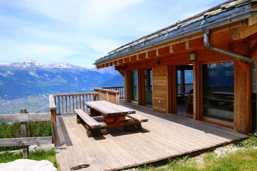 a wooden deck with a bench and a cabin at Egg SAUNA & LUXURY chalet 16 pers by Alpvision Résidences in Veysonnaz