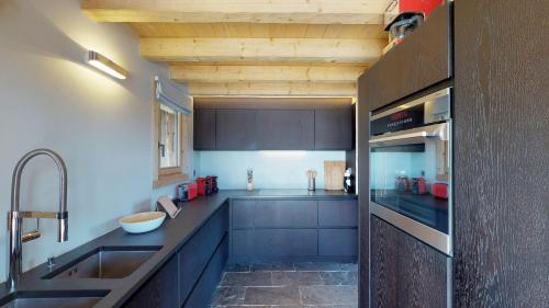 a kitchen with blue cabinets and a sink at Be Cool SAUNA & LUXURY chalet 10 pers by Alpvision Résidences in Les Collons