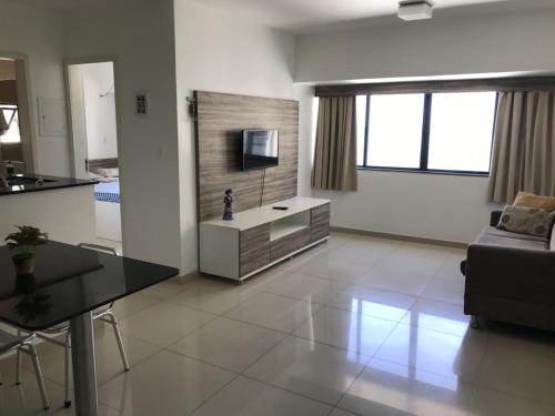 a living room with a couch and a tv in it at Studio Everest Flats in Recife