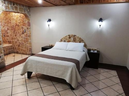 a bedroom with a bed and two lights on the wall at Hotel Cibeles Resort in Heredia