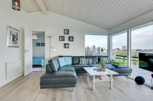 a living room with a couch and a table at Eksklusiv feriebolig med panoramaudsigt in Munkebo