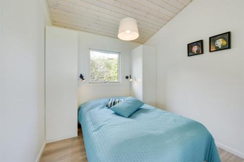 - une chambre avec un lit et une couverture bleue dans l'établissement Eksklusiv feriebolig med panoramaudsigt, à Munkebo