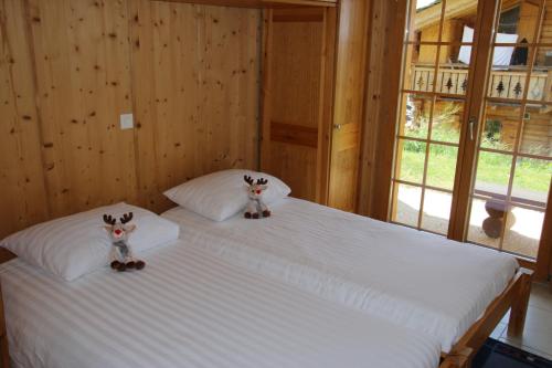 two stuffed animals sitting on a bed in a room at Christoph STANDING & CALM chalet 10 pers by Alpvision Résidences in Veysonnaz