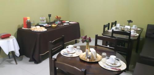 a dining room with two tables and chairs with food on them at CALDAS NOVAS RESIDENCE - Inclui um ingresso por pessoa em Parque Aquático e temos HOT PARK a preço promocional in Caldas Novas