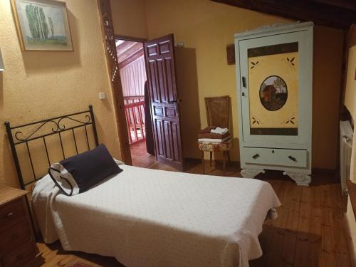 a bedroom with a bed in a room with a door at La cerca de la Mata, decerca in Arcones